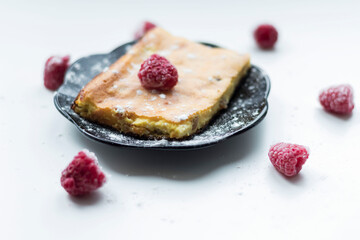 Appetizing curd casserole. Nearby is a drink and raspberries with raisins.