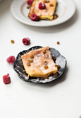 Appetizing curd casserole. Nearby is a drink and raspberries with raisins.
