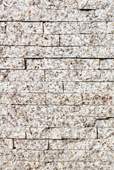 The wall is tiled with gray speckled granite tiles.