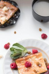Appetizing curd casserole. Nearby is a drink and raspberries with raisins.