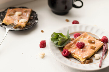 Appetizing curd casserole. Nearby is a drink and raspberries with raisins.