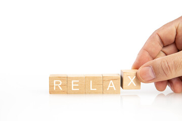 man hand building the word relax with wooden blocks 