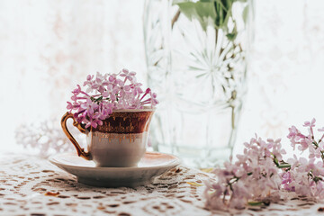 Retro tea cup with lilac flowers in it. Home decoration. Springtime vibes.