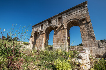 Fototapeta na wymiar The symbol of ancient Patara (Lycia) city - Arch of Mettius Modestus, Mediterranean coast of Turkey. Architecture Art and traveling around the world concept image.