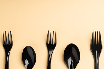 Forks and spoons on yellow background. Plastic cutlery, ecology, environmental pollution by plastic, disposable tableware, waste recycling concept. copyspace, text place