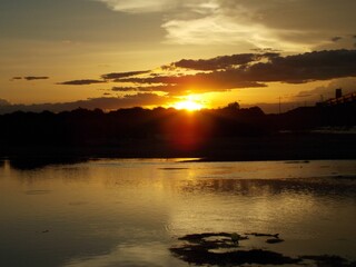 Hermoso ocaso, atardecer, puesta del sol en Islas del Río Paraná, en Argentina, reflejado en el agua