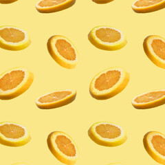 Seamless pattern of sliced flying orange grapefruit on yellow background. Cut orange grapefruit in pieces. Levity fruit floating in the air. Flying food concept. Applicable for fruit juice advertising