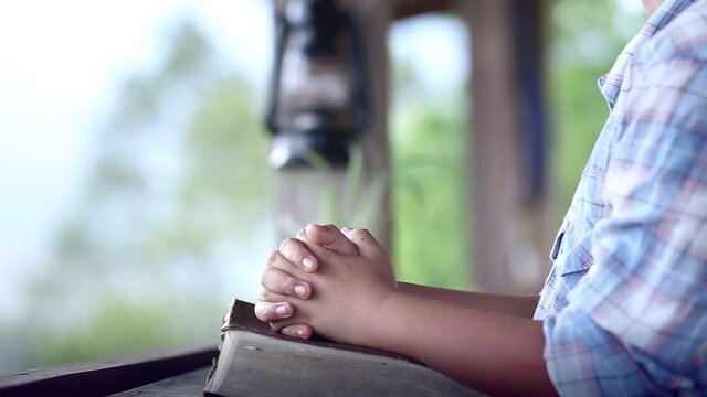 Close up hands of child praying on Bible, Pleading with wholehearted to God, Christian concept.