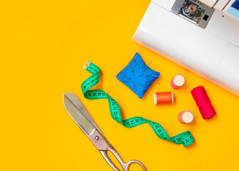 Sewing accessories. Composition with threads and sewing accessories on yellow background. Workplace of seamstress.Top view, copy space, flat lay