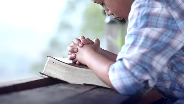 Hands of child praying with Bible, Pleading with wholehearted to God, Christian concept.