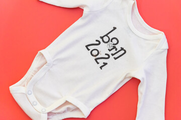 White baby clothes on pink flat background