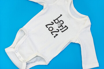 White baby clothes on blue flat background