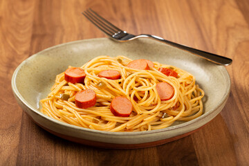 spaghetti pasta with sliced ​​sausages and tomato sauce.