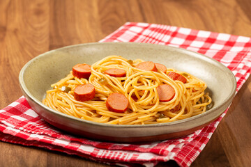 spaghetti pasta with sliced ​​sausages and tomato sauce.