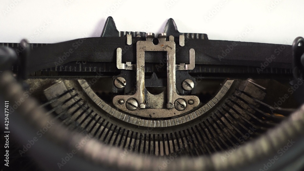 Fototapete the mechanism of an old typewriter. the text is printed. printed tape. metal letters. a sheet of whi