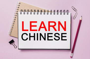 Text Learn Chinese a white notepad with office stationery background. Flat lay on business, finance and development concept