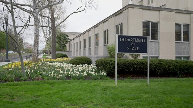 Department Of State Sign In Front Of Harry S Truman Department Of State Building In Washington, DC On An Overcast Day.