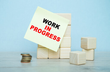 the words WORK IN PROGRESS is written on the sticker , a wooden cubes structure. Can be used for...
