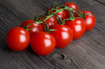 Bunch of ripe delicious red cherry tomatoes close-up on wooden background