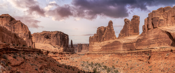 Panoramic American landscape view of Scenic red rock canyons. Artistic Sky Colorful Render. Taken in Arches National Park, located near Moab, Utah, United States. Nature Background Panorama