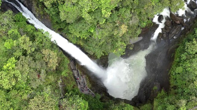 Aerial view of el pailon del diable with many tourist at the small terrace next to the waterfall