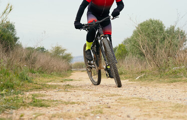Fototapeta na wymiar Unrecognizable cyclist man with a mountain bike pedaling down the mountain