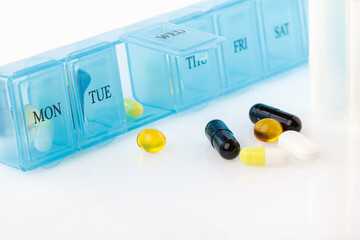 Pill organizer with variety of pills and supplement. Weekly Pill Organizer on white background....