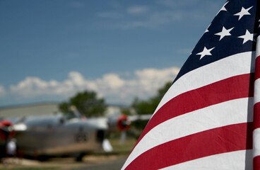 American flag waving to the wind with old airplane in the background