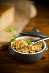 homemade meat pate in a ceramic bowl on a wooden table