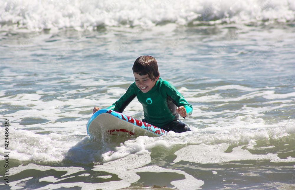 Wall mural boy is very happy practicing surfing and overcoming challenges