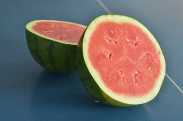 whole and half watermelon isolated in blue background