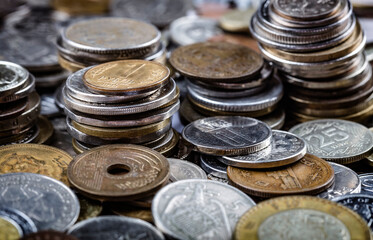 Various multi-colored coins of the currency of the whole world stacked on top of each other. The concept of banking, currency exchange, globalization, money, wealth
