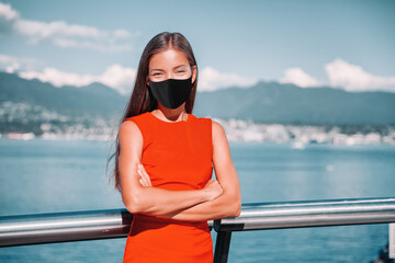 Asian businesswoman wearing face mask as coronavirus prevention. Confident multiracial business lady outside portrait smiling during pandemic in Vancouver, Canada.