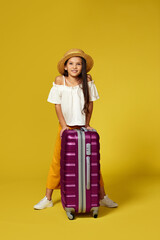 Happy little child girl in hat with pink suitcase