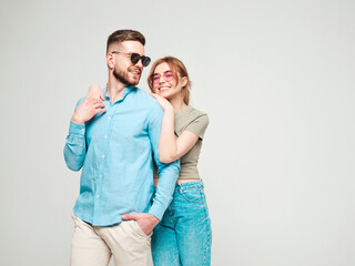 Smiling beautiful woman and her handsome boyfriend. Happy cheerful family having tender moments on grey background in studio.Pure cheerful models hugging.Embracing each other in sunglasses
