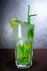 a sweaty glass of mojito with mint and lime