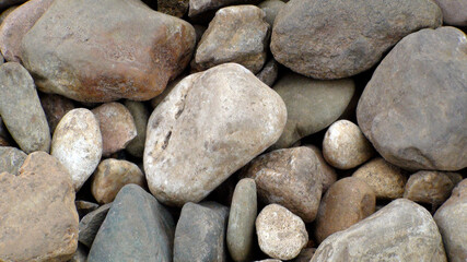 Cobblestones close up. Coarse gravel on the road. Gray stones of various sizes for construction.
