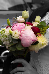 A bouquet of peony flowers in the hands of the bride