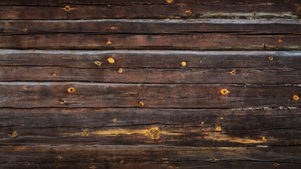 brown grunge background from old log wall of rustic hut for creative backdrops, decoration or stylish design