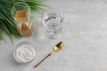 A glass of water, collagen powder on a light background. Healthy lifestyle concept. Hydrolyzed collagen in a glass cup and gold spoon. Natural beauty supplement. Copy space.