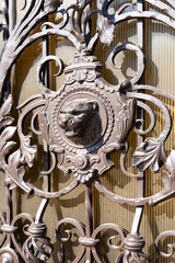 Fototapeta na wymiar Decorating the metal gate with wrought iron elements, the tiger's head is made of metal