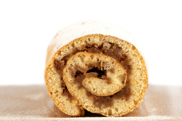 Close-up cut of apple roll sprinkled with powdered sugar.