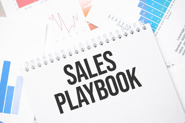 sales playbook text on paper on the chart background with pen