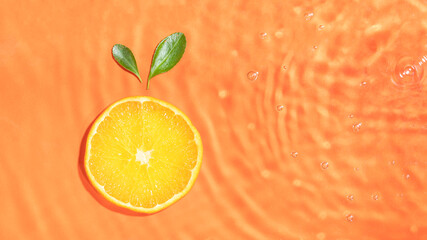 Trendy summer flat lay with organic orange fruit slice and leaves in sunny water. Creative fresh nature background with copy space.