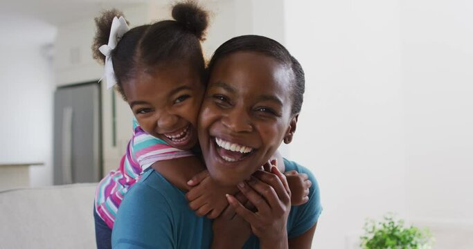 Portrait of happy african american mother and daughter hugging at home