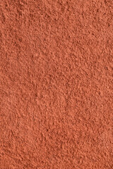 Fototapeta premium Decorative plaster of terracotta color with small pimples, wall surface.Overlay texture for interior or exterior design.Decorative render. Monolithic plaster decorative vertical background and sample