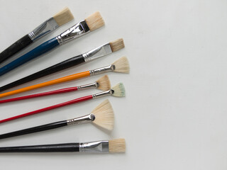 Obraz premium various gently used brushes for oil and acrylic painting on a white gessoed background
