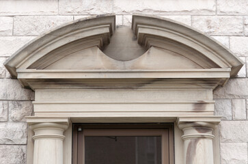 detail of a stone segmental or curved broken pediment and door