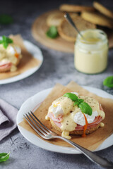 Egg benedict sandwiches - muffin with poached egg, ham and hollandaise sauce