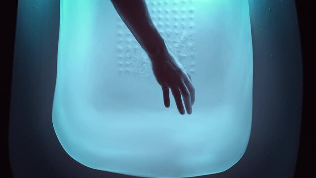 The hand check water in the pool with cold color lighting